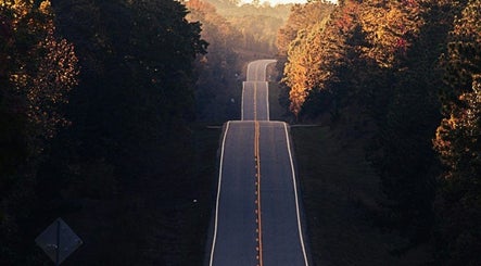 A winding road at sunset near Jenni Moresco Therapy, Baldock, England, GB.