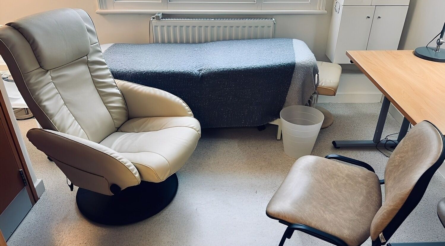 Cozy therapy room at Jenni Moresco Therapy in Baldock, England, featuring comfortable chairs and a therapy bed.