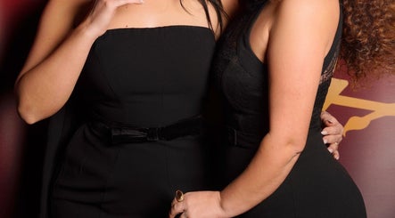 Two women in elegant black dresses at Desada Beauty Lounge, Barking, England, GB.