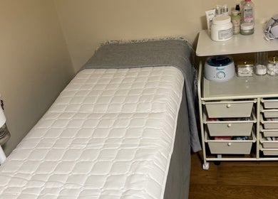 Cozy treatment room at Faya Beauty Studio in London, England, GB featuring a plush bed and organized skincare essentials.