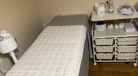 Cozy treatment room at Faya Beauty Studio in London, England, GB featuring a plush bed and organized skincare essentials.