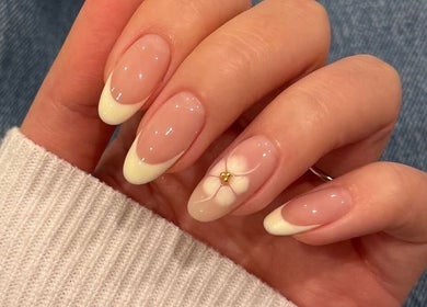 Floral nail art at 24 Nails, Leeds, England, GB. Features delicate white flowers with gold accents on natural nails.