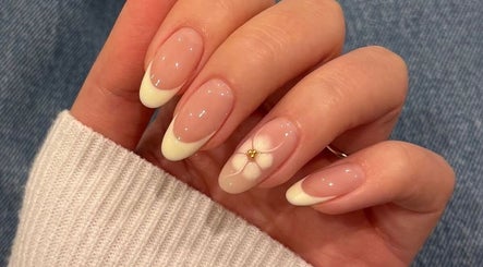 Floral nail art at 24 Nails, Leeds, England, GB. Features delicate white flowers with gold accents on natural nails.