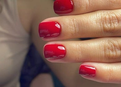 Close-up of glossy red gel nails from 24 Nails in Leeds, England, GB, showcasing premium nail art.