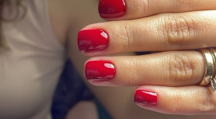 Close-up of glossy red gel nails from 24 Nails in Leeds, England, GB, showcasing premium nail art.