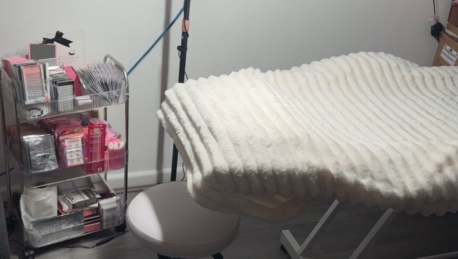 Comfortable eyelash treatment bed at TheLashLab, Bettws, Wales, GB, surrounded by beauty supplies.
