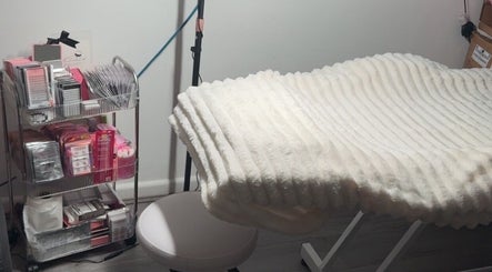 Comfortable eyelash treatment bed at TheLashLab, Bettws, Wales, GB, surrounded by beauty supplies.