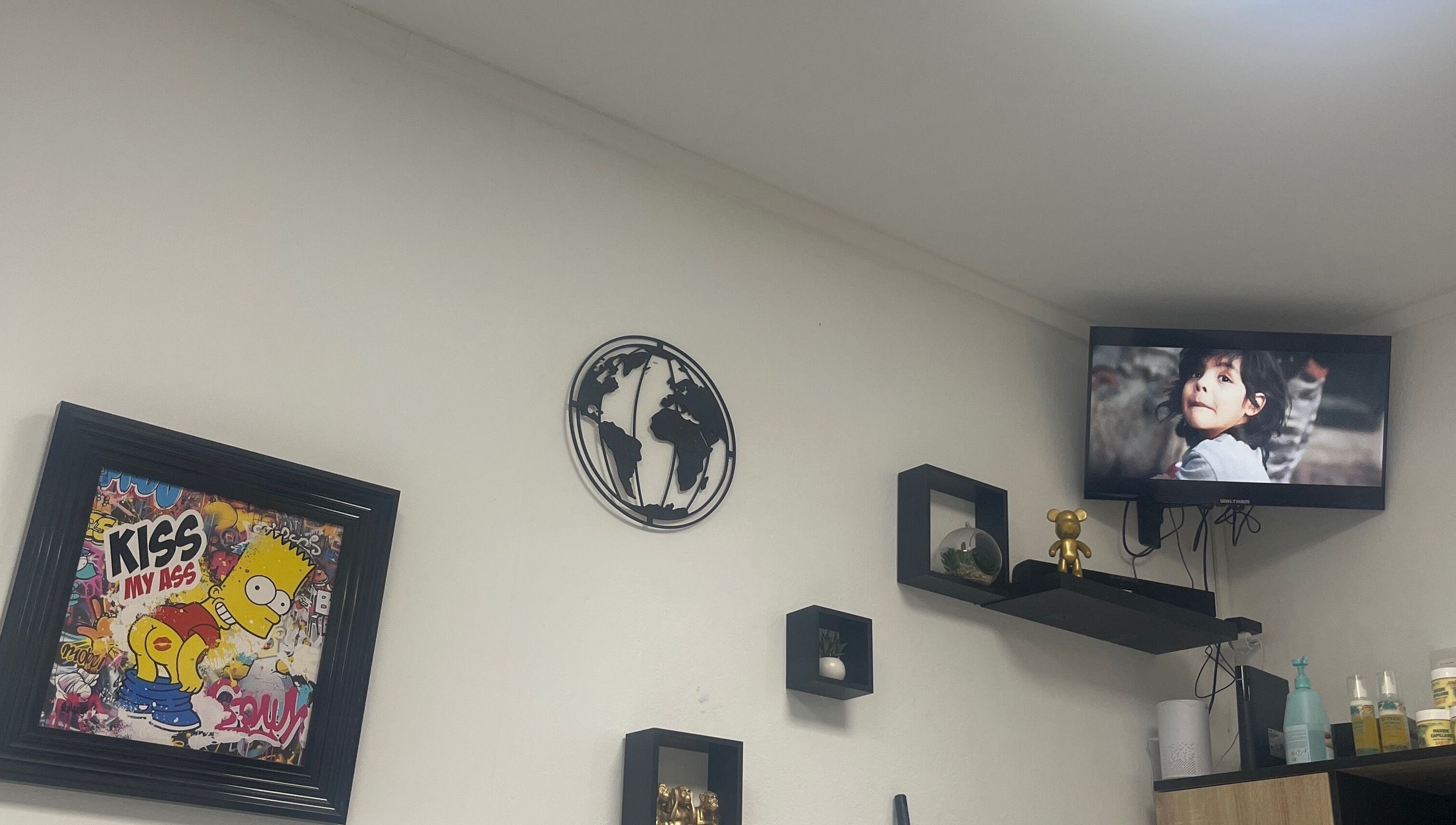Décor moderne à Universal’s barber, Le Moule, Grande-terre avec affiches et étagères murales.