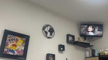 Décor moderne à Universal’s barber, Le Moule, Grande-terre avec affiches et étagères murales.