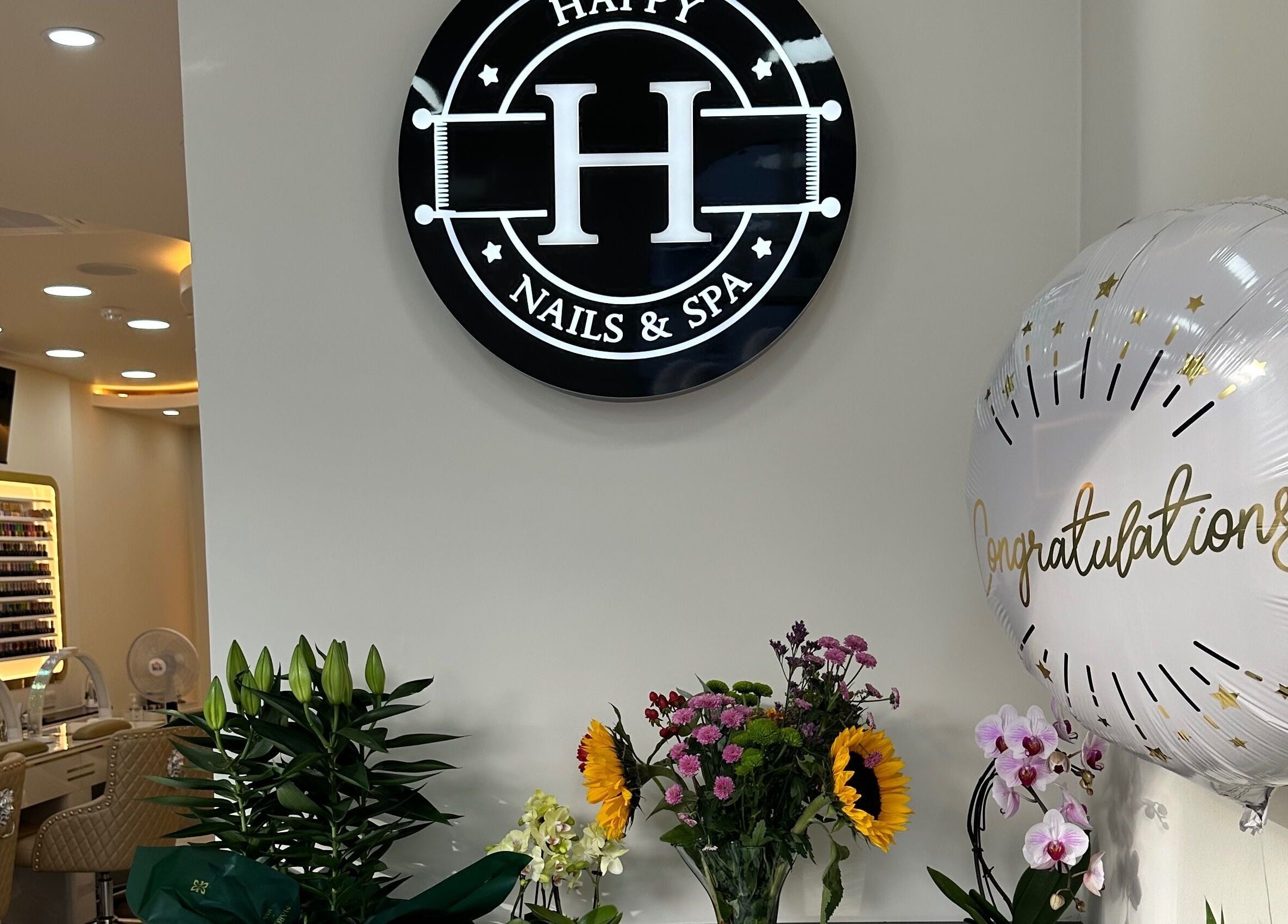 Interior of Happy Nails Doncaster, England, featuring chic seating and vibrant flower arrangements.