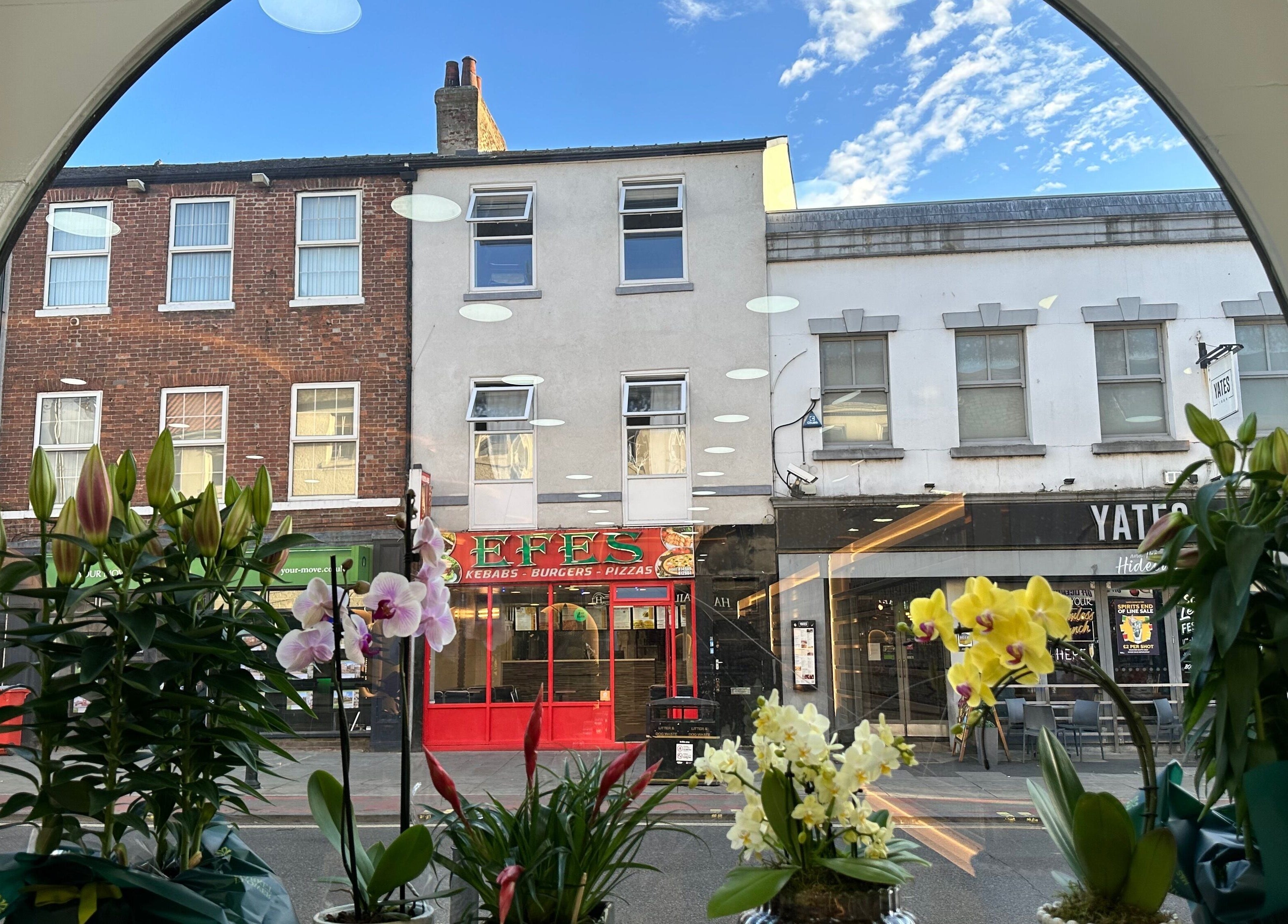 Vibrant orchids in the window of Happy Nails Doncaster, overlooking the bustling street in Doncaster, England, GB.
