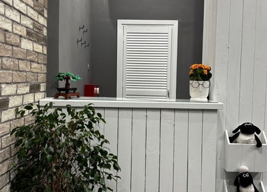 Κομψός χώρος υποδοχής στο Gossheep Barbershop, Θεσσαλονίκη, GR με φυτά και μοντέρνα διακόσμηση.