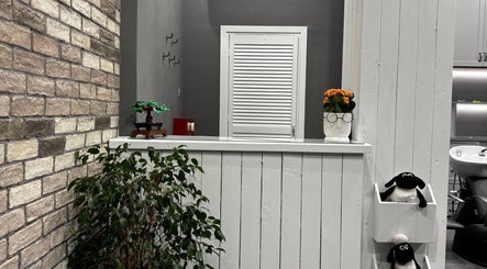 Κομψός χώρος υποδοχής στο Gossheep Barbershop, Θεσσαλονίκη, GR με φυτά και μοντέρνα διακόσμηση.