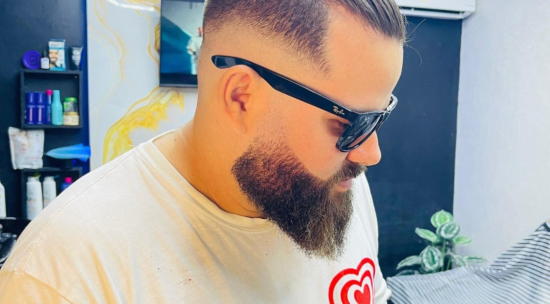 Cliente en D'Ransel barbershop, La Habana, CU, con corte moderno y barba cuidada.