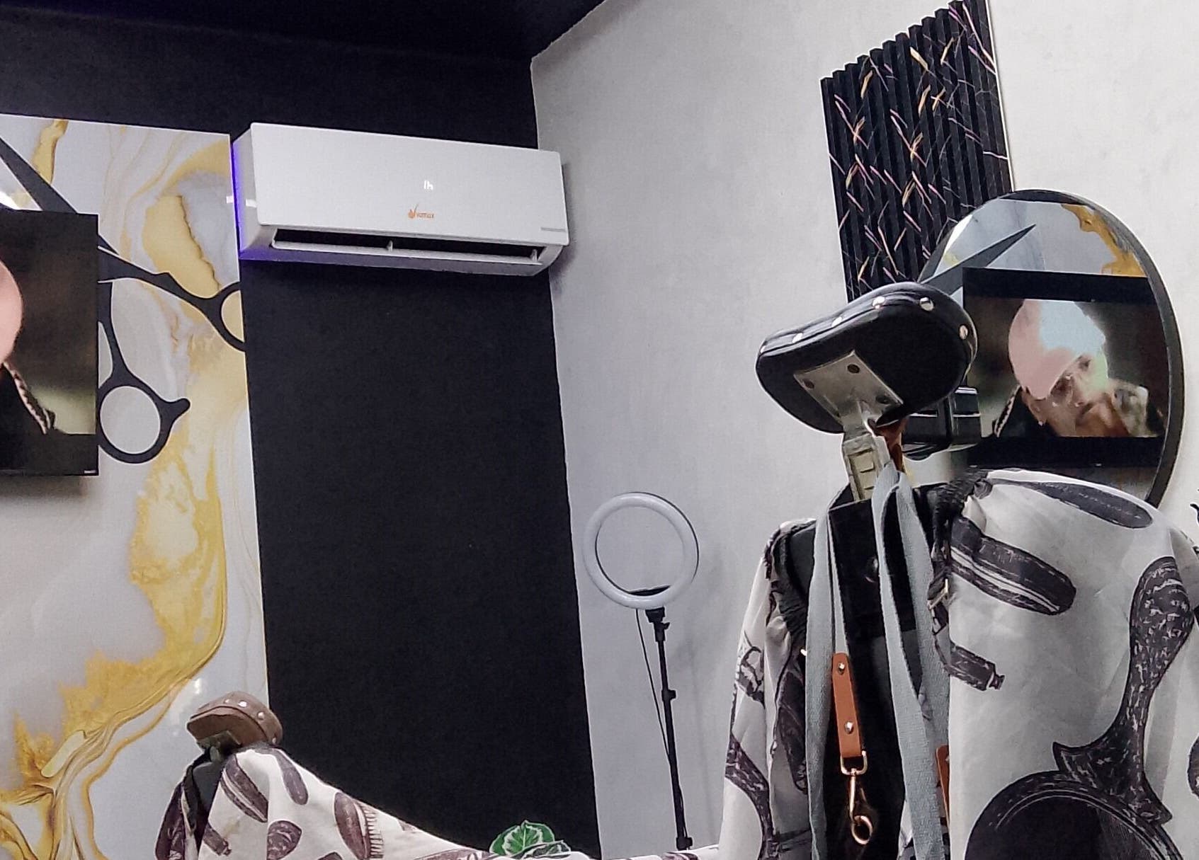 Interior moderno de D'Ransel barbershop en La Habana, mostrando silla y pantalla en pared decorada.