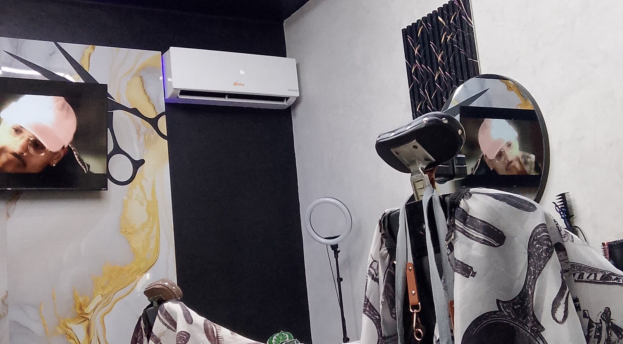 Interior moderno de D'Ransel barbershop en La Habana, mostrando silla y pantalla en pared decorada.