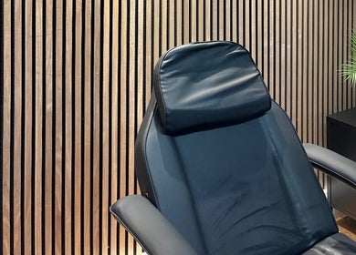 Luxurious treatment chair in Skin Plus, Burgh Le Marsh, England, GB, set against a stylish wooden wall.