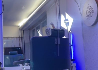 Intérieur moderne de bhm barber à Vernier, Genève, CH, avec un éclairage bleu sophistiqué.