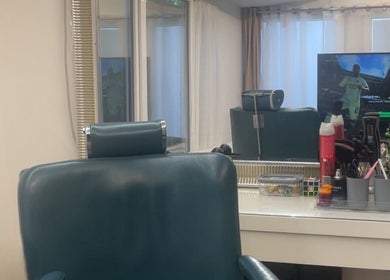 Intérieur chic du bhm barber à Vernier, Genève, CH, avec un fauteuil moderne et un miroir élégant.
