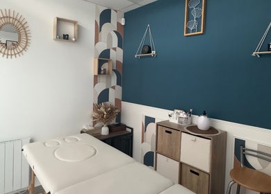 Salle de soin de L’instant douceur, Maillot, Bourgogne-franche-comté, FR avec lit de massage et décoration apaisante.