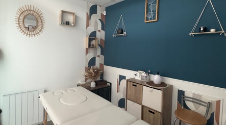 Salle de soin de L’instant douceur, Maillot, Bourgogne-franche-comté, FR avec lit de massage et décoration apaisante.