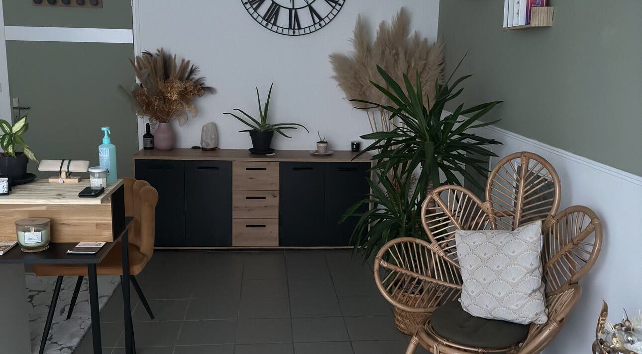 Coin détente élégant chez L’instant douceur à Maillot, Bourgogne-franche-comté, FR, décoré de plantes et fauteuil en osier.