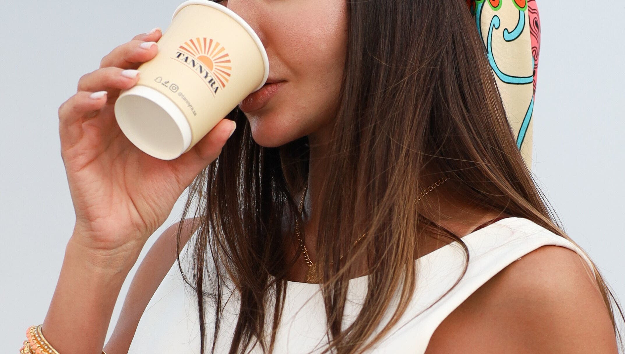 A woman enjoying coffee at Tannyra, Riyadh, Riyadh Province, SA, showcasing relaxation and style.
