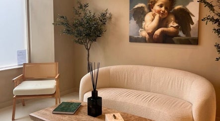 Elegant waiting area at Dr Sophie Aesthetics in Clarkston, Scotland, GB with cozy seating and art decor.
