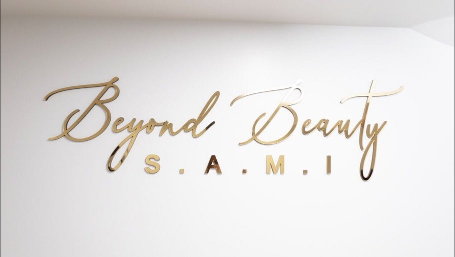 Elegant gold logo of BeyondBeautySami on white wall in Toronto, Ontario, CA.
