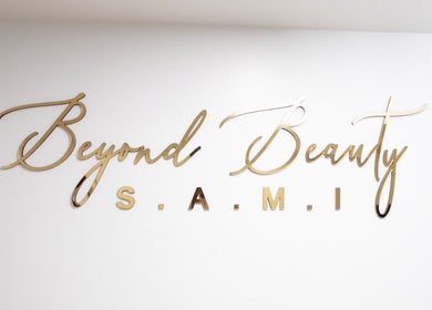 Elegant gold logo of BeyondBeautySami on white wall in Toronto, Ontario, CA.