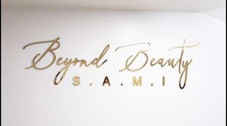 Elegant gold logo of BeyondBeautySami on white wall in Toronto, Ontario, CA.