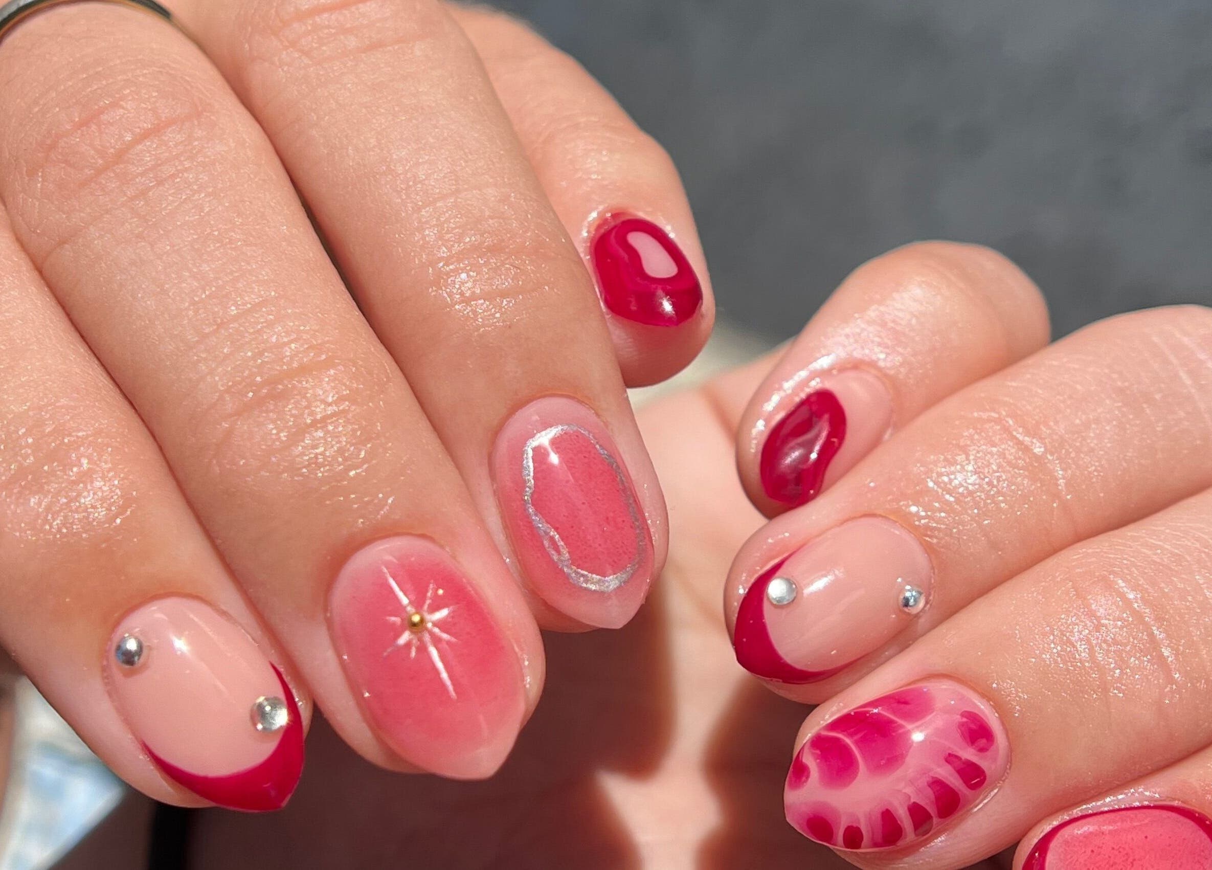 Vibrant nail art at Luxe Nails & Studio, San Juan, San Juan, PR. Showcasing pink and red designs with embellishments.