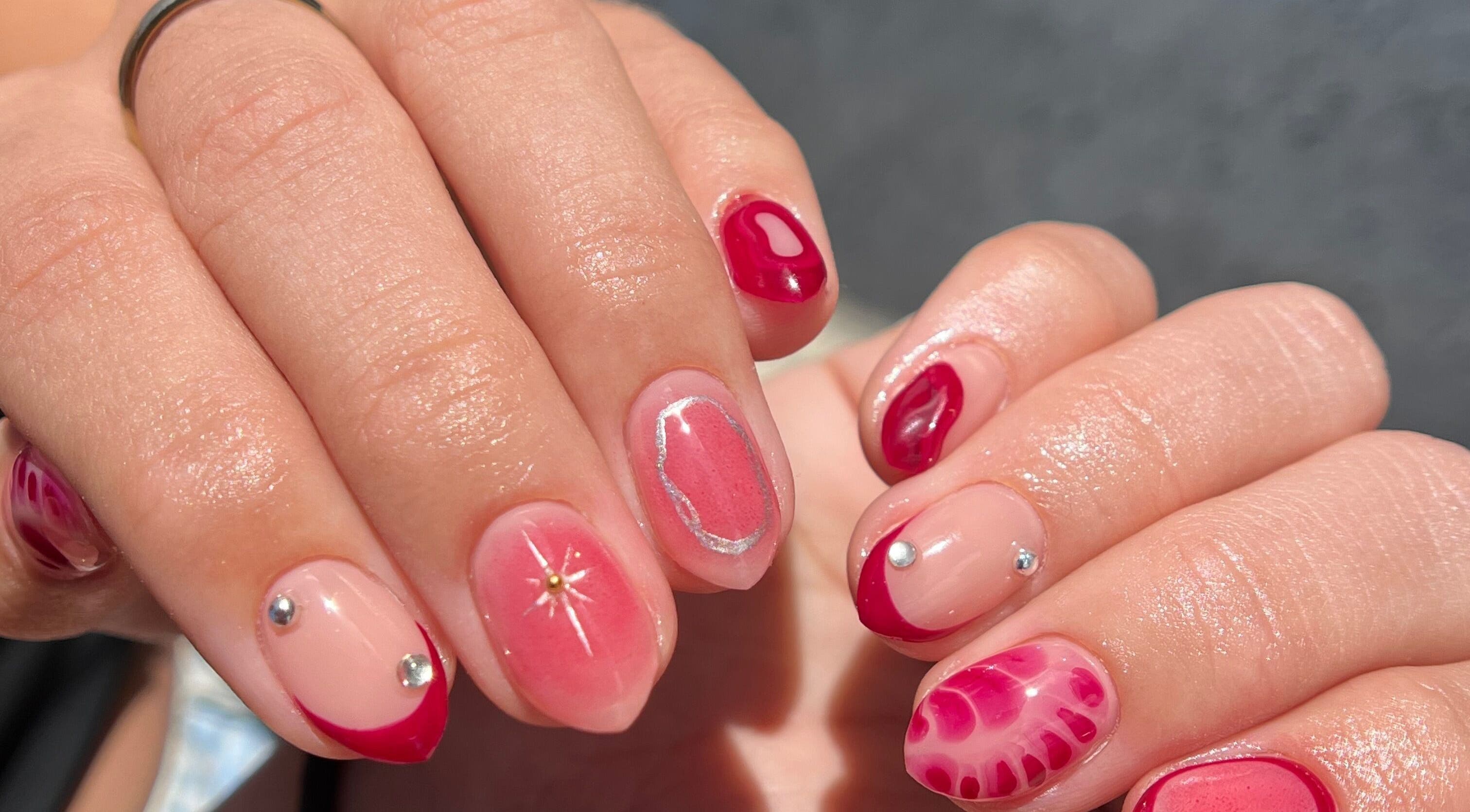 Vibrant nail art at Luxe Nails & Studio, San Juan, San Juan, PR. Showcasing pink and red designs with embellishments.