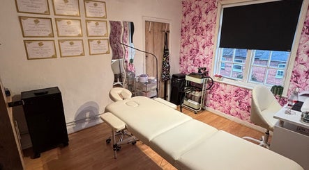 Treatment room at KK Aesthetic, Braintree, England, GB with floral wallpaper and a comfortable treatment bed.