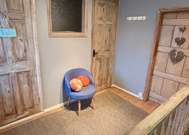 Cozy corner at KK Aesthetic in Braintree, England, GB with a rustic wooden door and a plush blue chair.