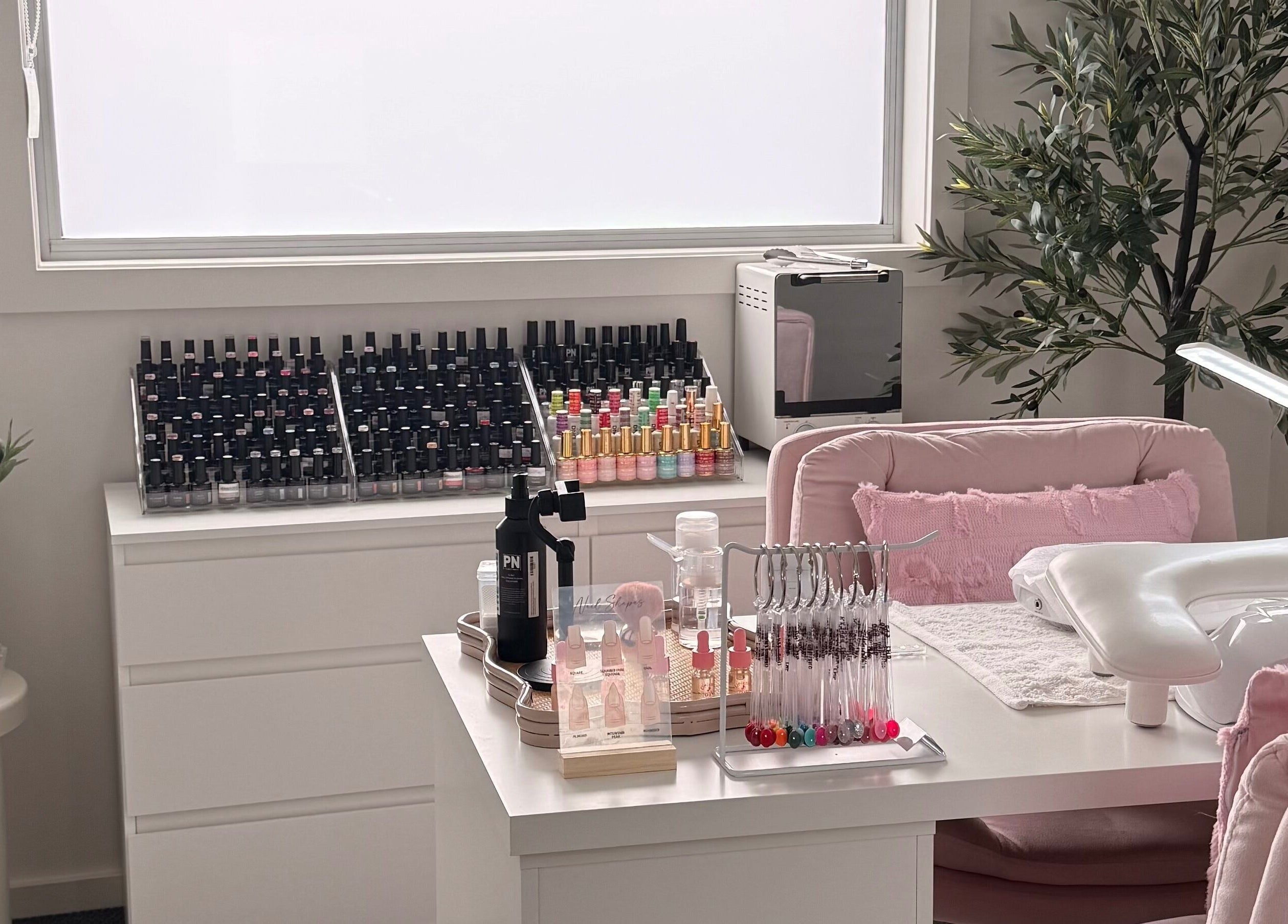 Chic nail art station at Manifest Nail Artistry, Mount Barker, South Australia, AU with polish and greenery.