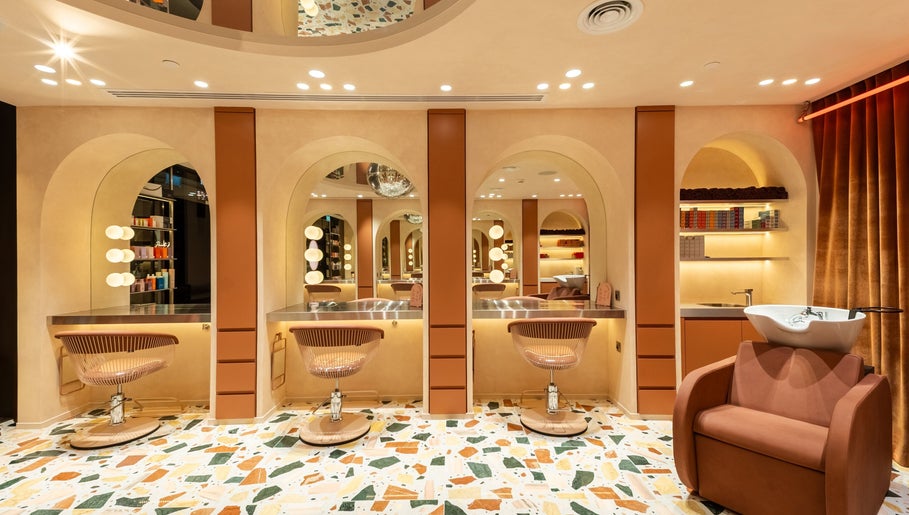 Luxurious salon interior at Beauty Club London in دبي, دبي, AE featuring modern styling stations.