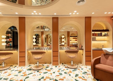 Luxurious salon interior at Beauty Club London in دبي, دبي, AE featuring modern styling stations.