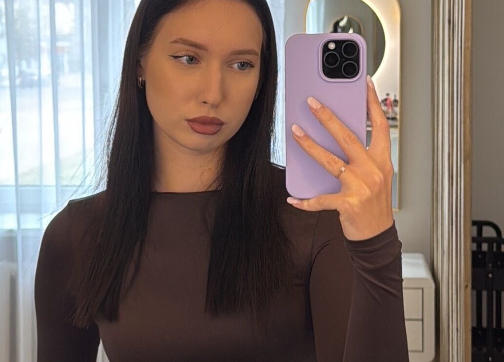 Клиент в Linushka Beauty Studio в Jelgava, LV делает селфи в зеркале.