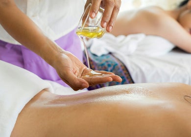Massage therapy with oil at Mmmassage, Hastings, England, GB. A serene client enjoys a relaxing session.