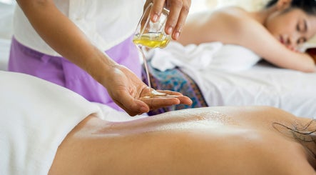 Massage therapy with oil at Mmmassage, Hastings, England, GB. A serene client enjoys a relaxing session.