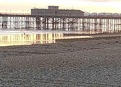 Sunset over Hastings Pier near Mmmassage venue, Hastings, England, GB with serene ocean reflections.