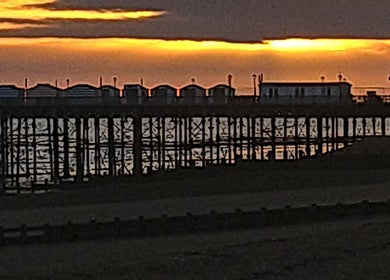 Dramatic sunset over pier near Mmmassage, Hastings, England, GB.