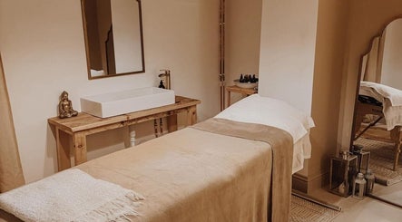 Massage room at Qui Yoga & Ayurveda - Exeter, featuring a cozy treatment table and serene decor, Exeter, England, GB.