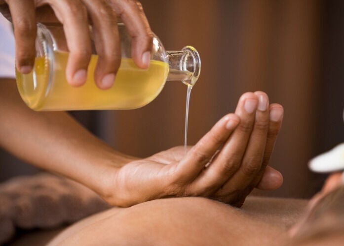 Massage oil being poured at Qui Yoga & Ayurveda - Topsham, Topsham, England, GB for wellness therapy.