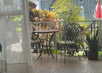 Charming patio at Salon Müller, Grand Baie, Rivière Du Rempart District, MU, featuring lush greenery and cozy seating.