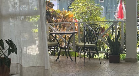 Charming patio at Salon Müller, Grand Baie, Rivière Du Rempart District, MU, featuring lush greenery and cozy seating.