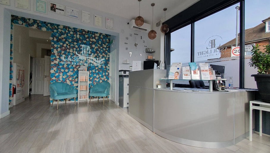 Reception area of Laser Light Skin Clinic in Dagenham, England, GB with blue floral wall and brochures.