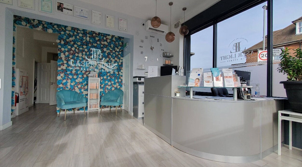 Reception area of Laser Light Skin Clinic in Dagenham, England, GB with blue floral wall and brochures.