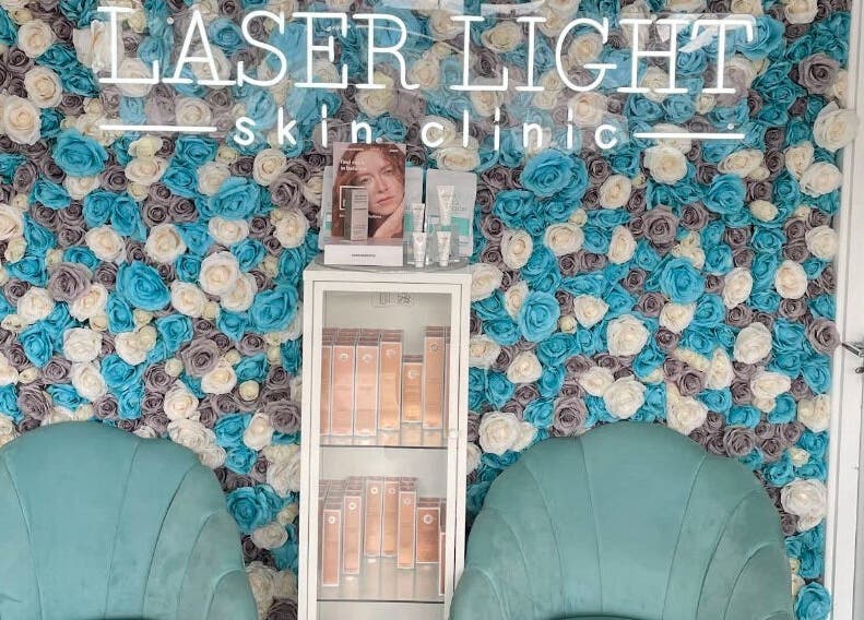 Elegant floral wall at Laser Light Skin Clinic, Dagenham, England, GB with a display of skincare products.